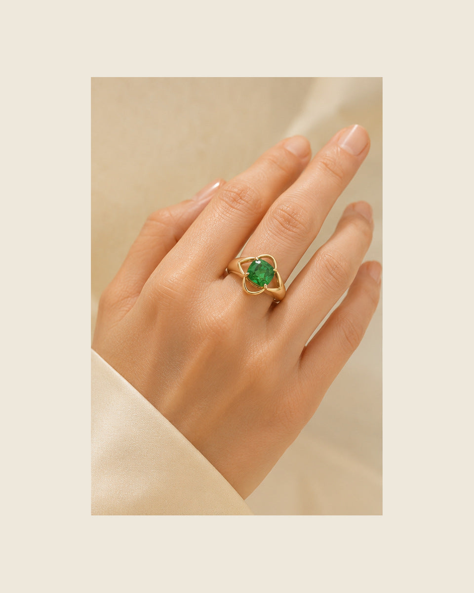 Aurea Forma Petal Ring — Emerald — shown worn by a woman for scale