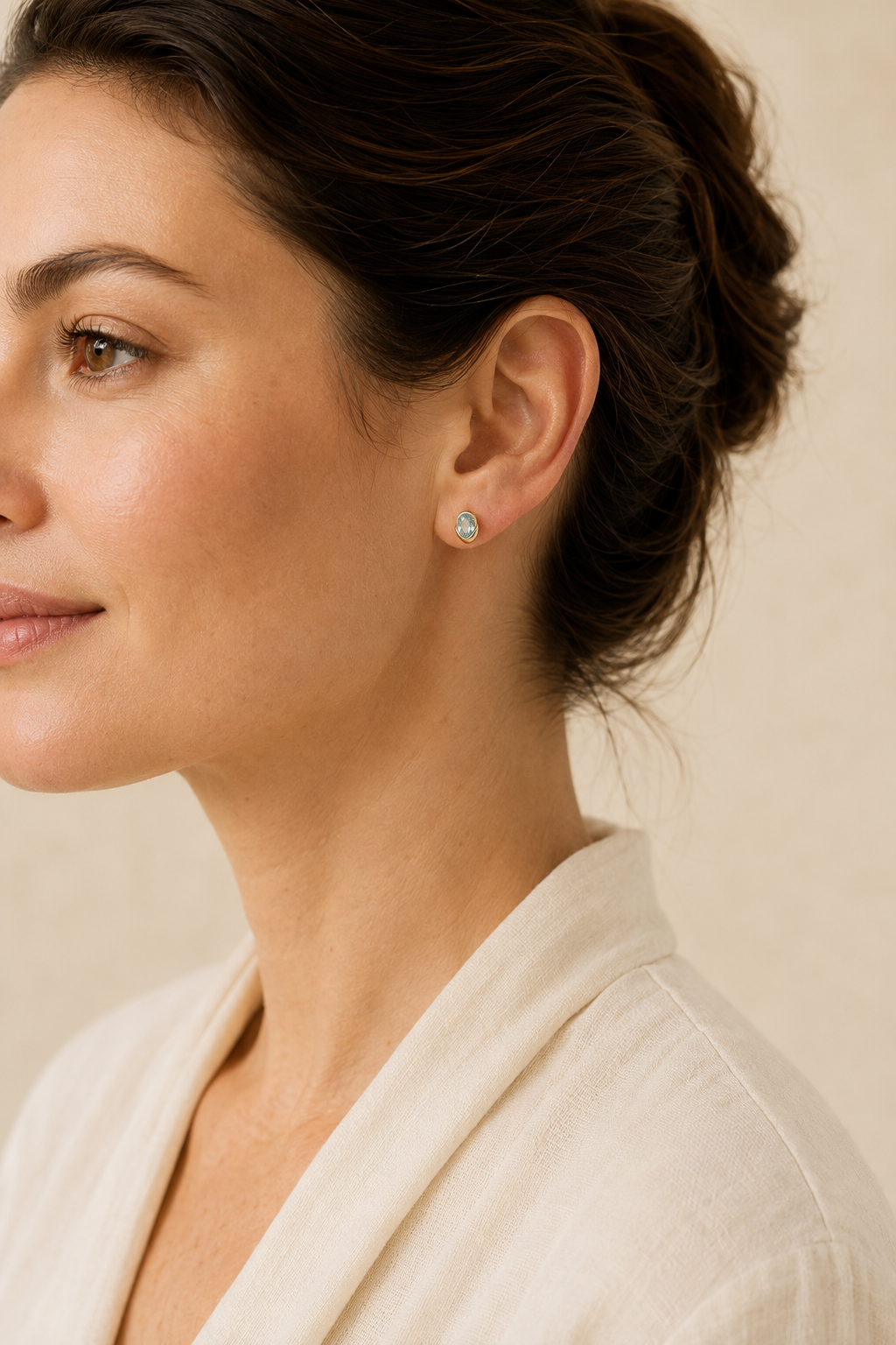 Adult woman wearing Veil Aquamarine Petal Studs — 14k Gold at approximate scale with modest ivory styling