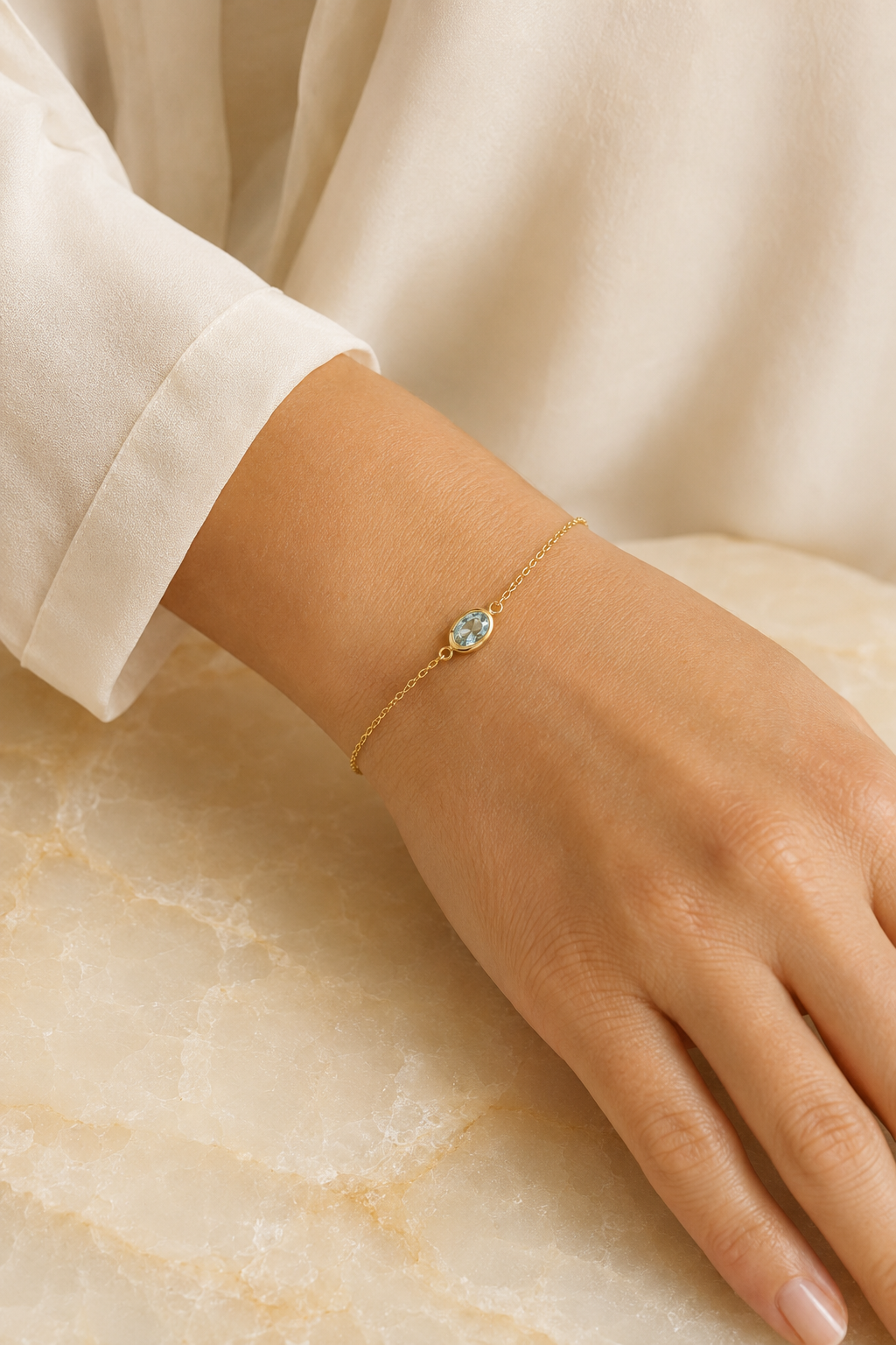 Adult woman wearing Veil Aquamarine Thread Bracelet — 14k Gold at approximate scale with modest ivory styling