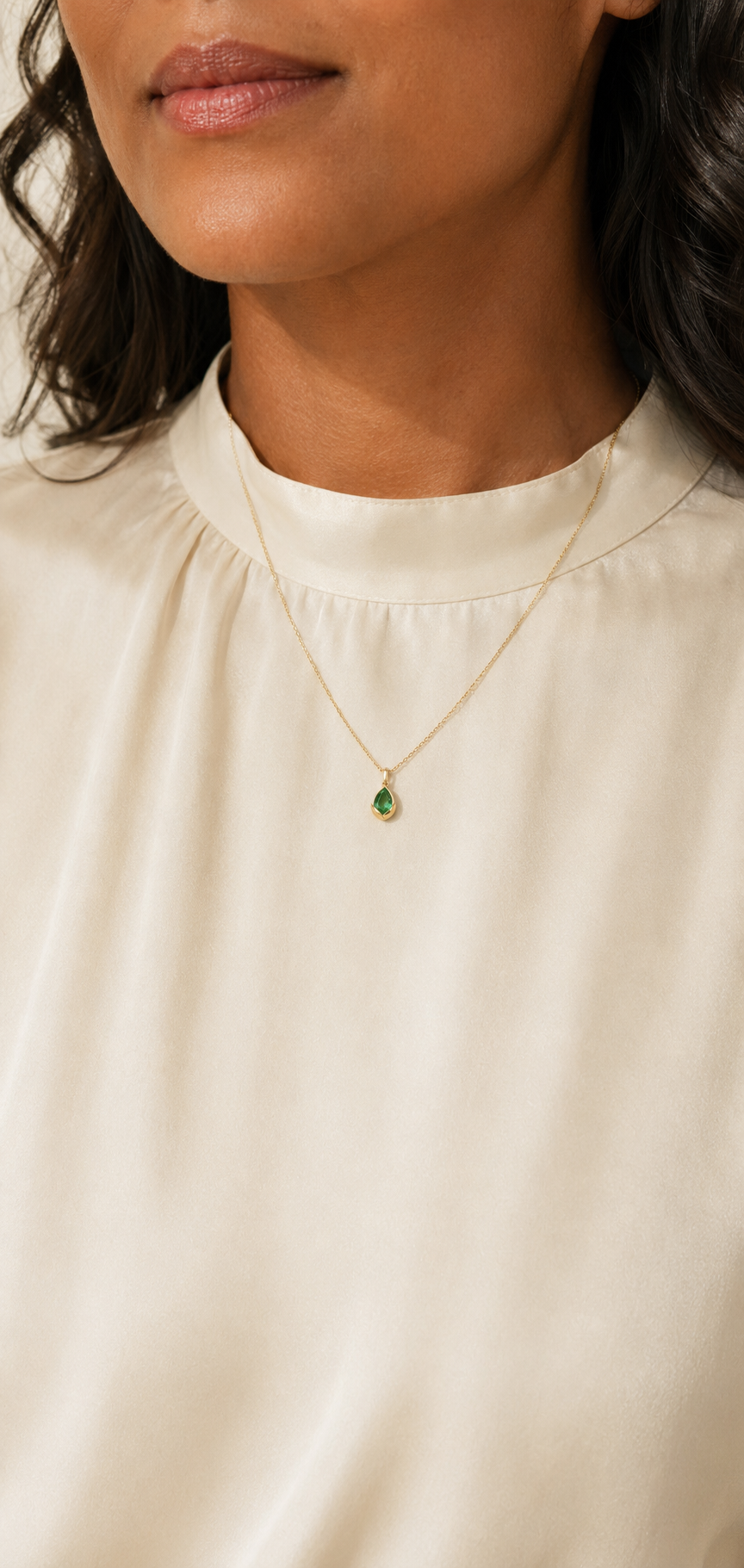 Adult woman wearing Veil Emerald Dew Necklace — 14k Gold at approximate scale with modest ivory styling