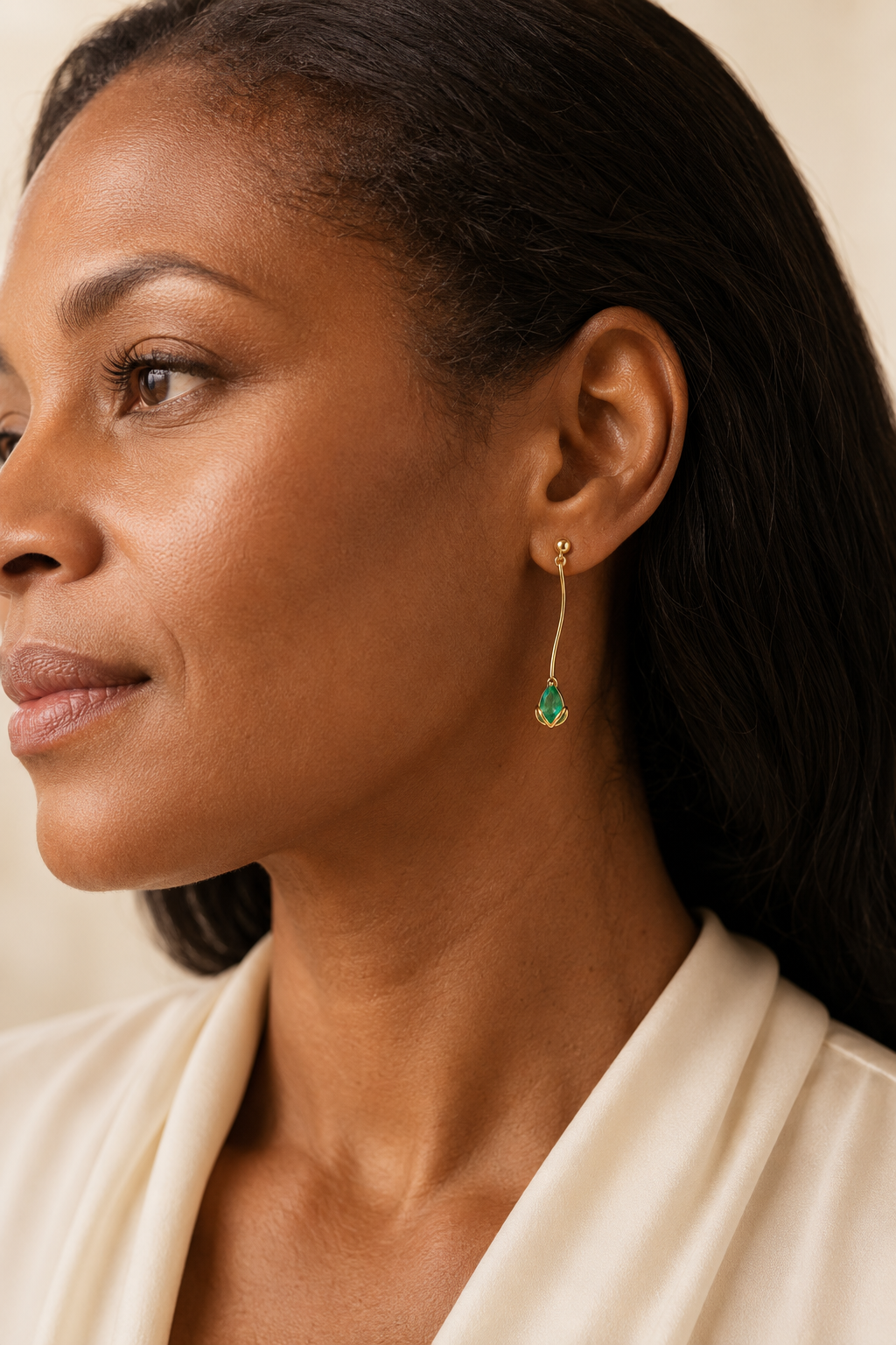 Adult woman wearing Veil Emerald Drop Earrings — 14k Gold at approximate scale with modest ivory styling