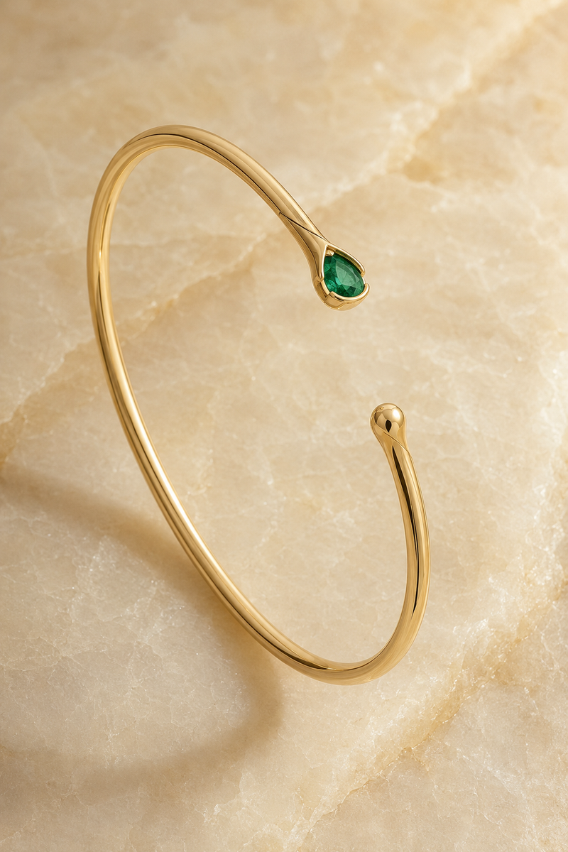 Veil Emerald Whisper Bangle — 14k Gold product visualization on warm alabaster