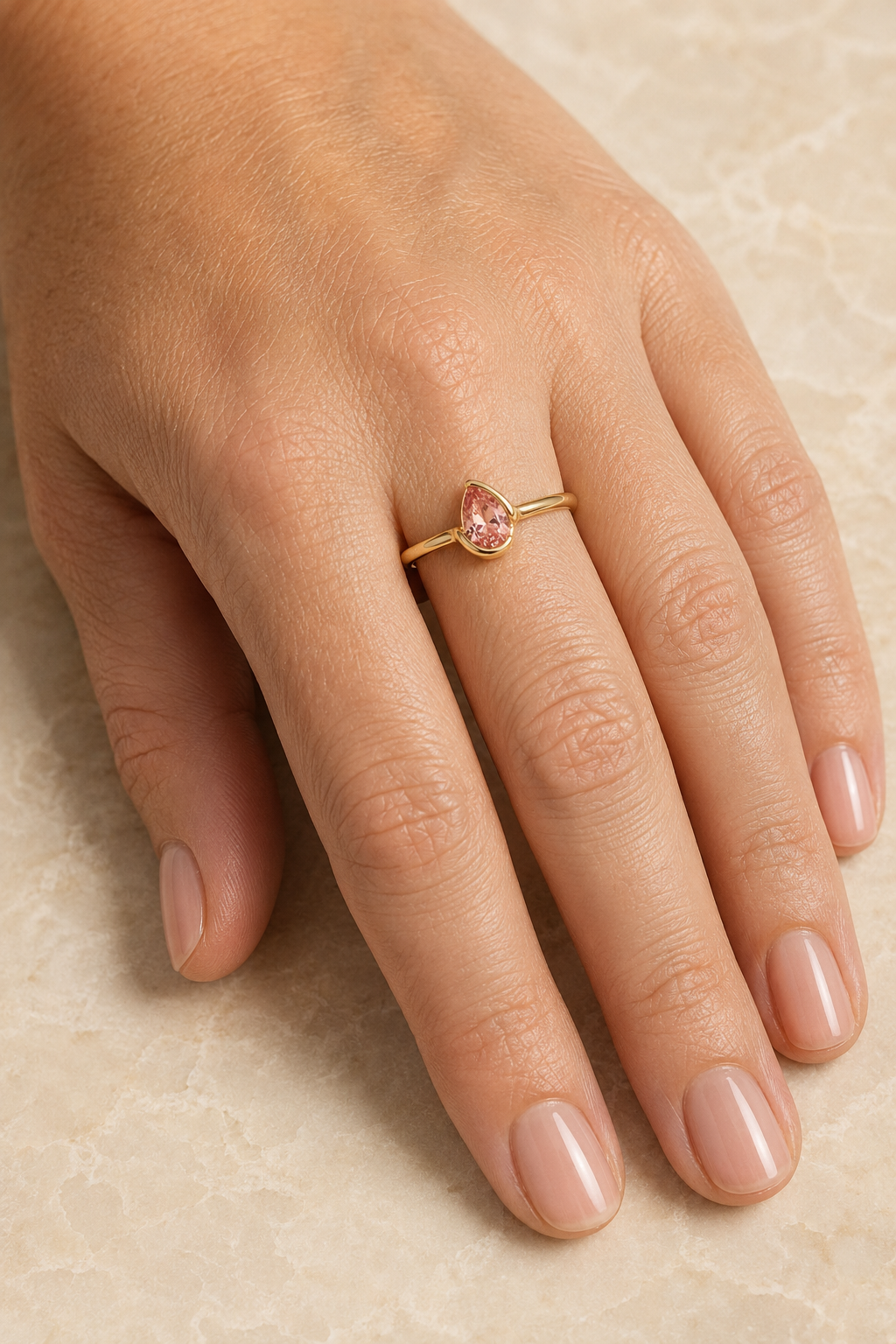 Adult woman wearing Veil Pink Spinel Petal Ring — 14k Gold at approximate scale with modest ivory styling