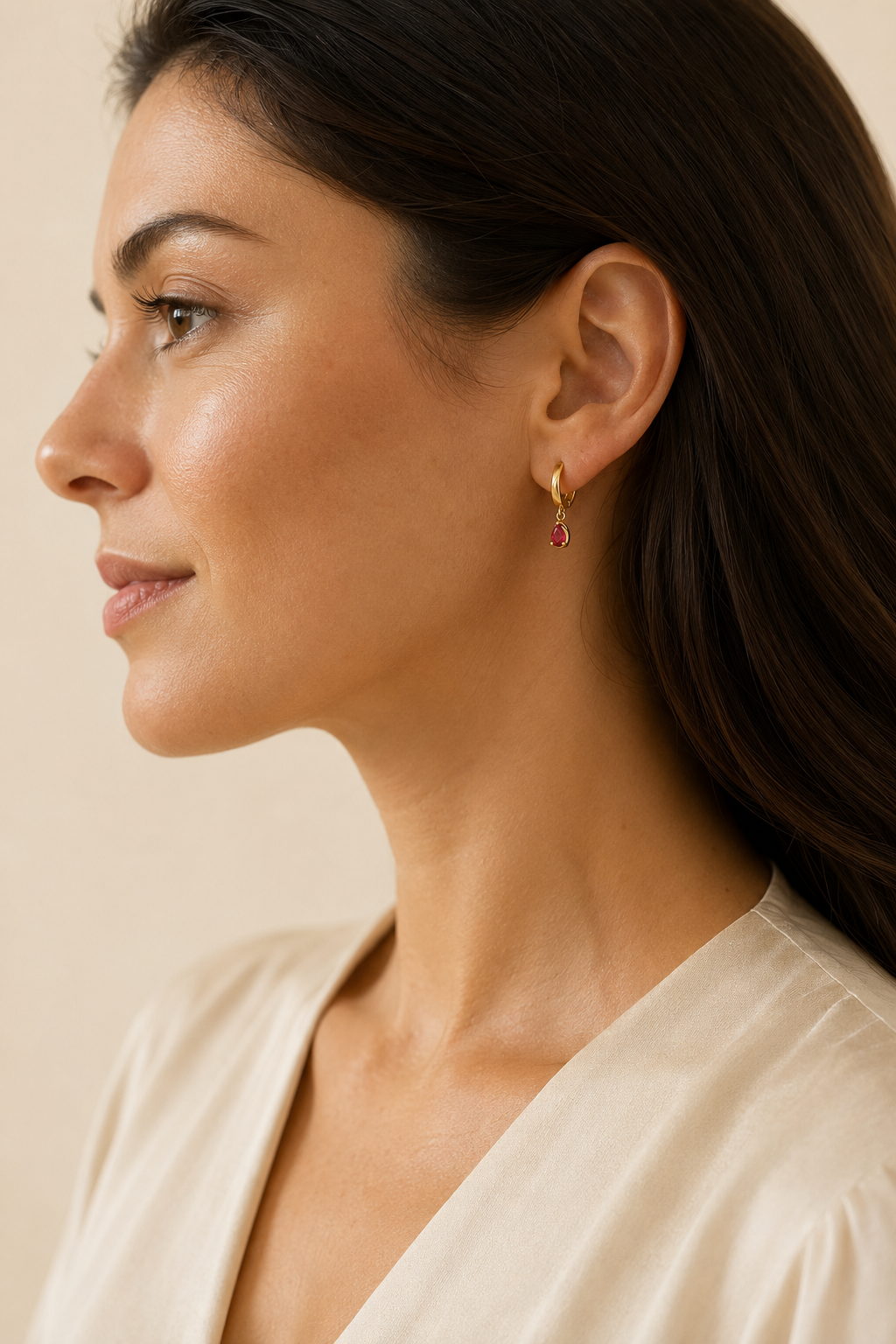 Adult woman wearing Veil Ruby Huggies — 14k Gold at approximate scale with modest ivory styling