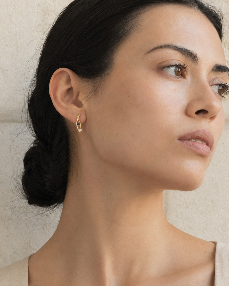 Forgemier Comet Run Earrings in 14k yellow gold with sapphire, shown worn to scale