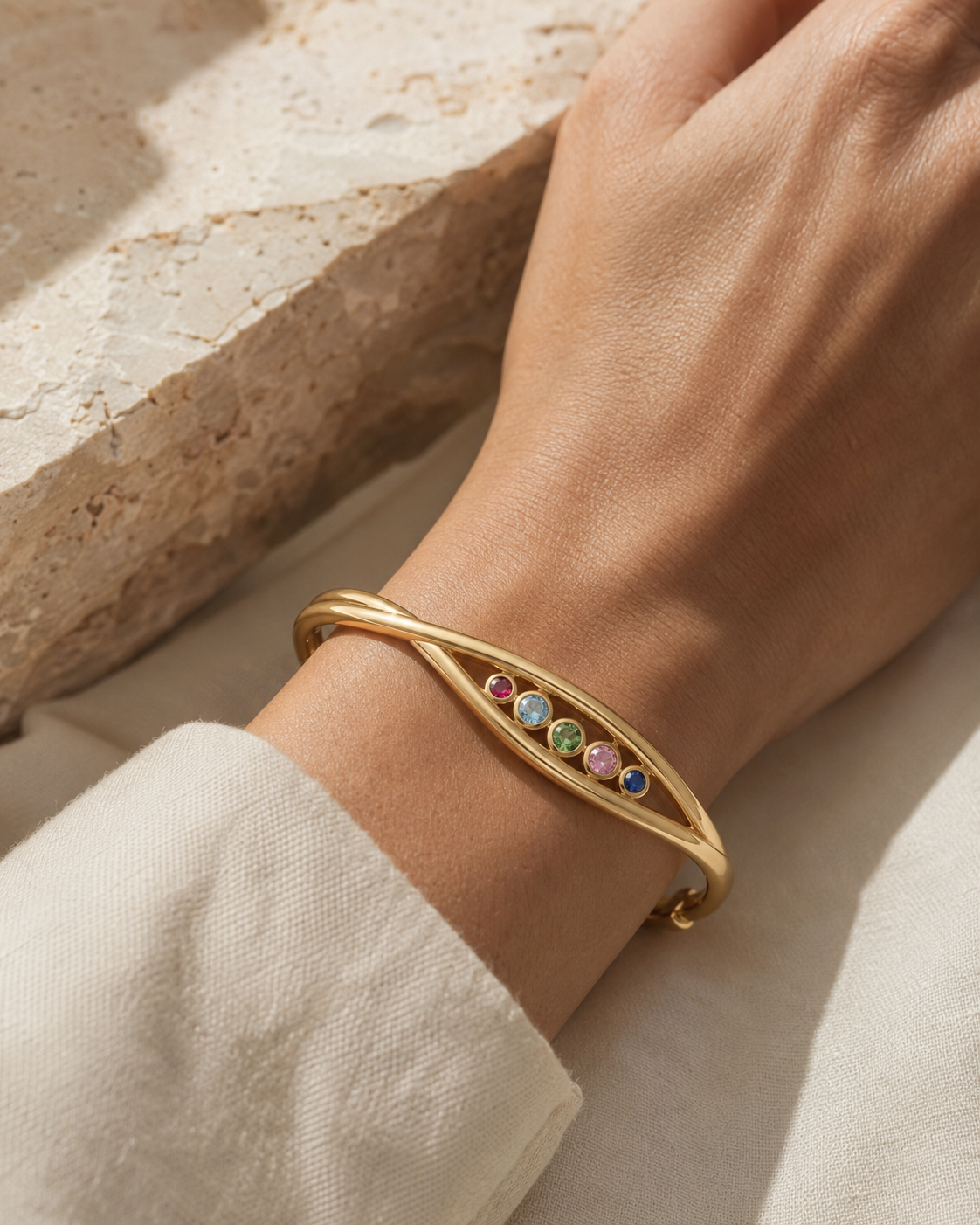 Forgemier Current Slider Bangle in 14k yellow gold with five sliding gemstones, shown worn to scale