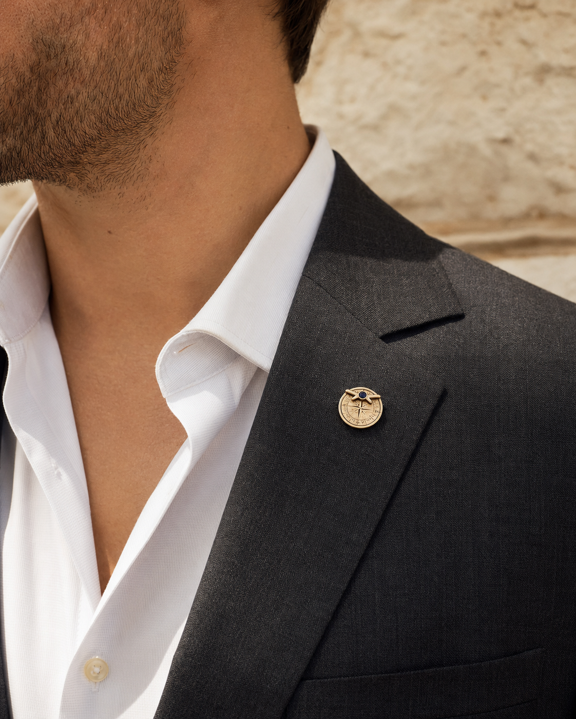 Forgemier True North Spinner Lapel Pin in 14k yellow gold with blue sapphire, shown worn to scale