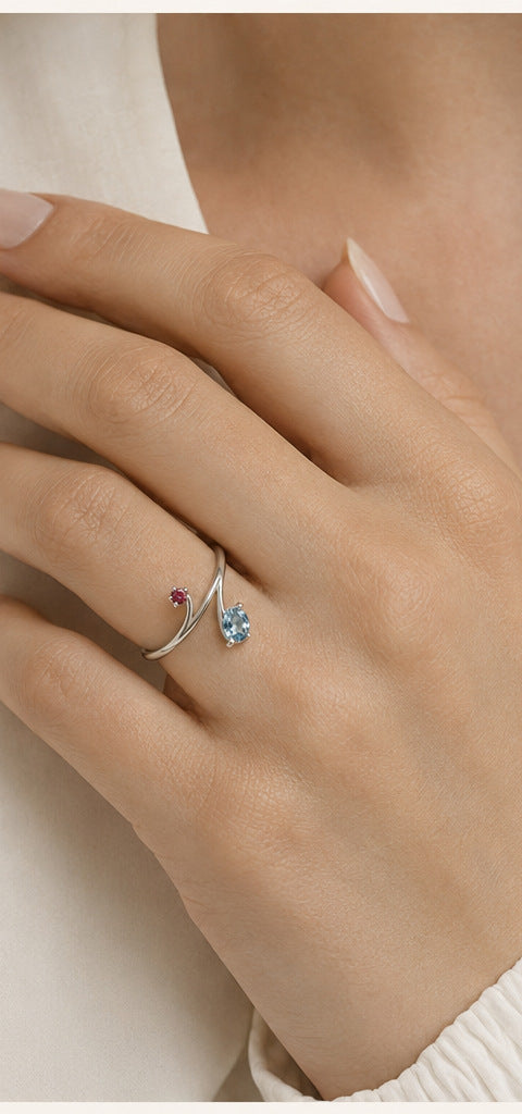 Lilt Bypass Ring — Aquamarine & Ruby — shown worn by a woman for scale